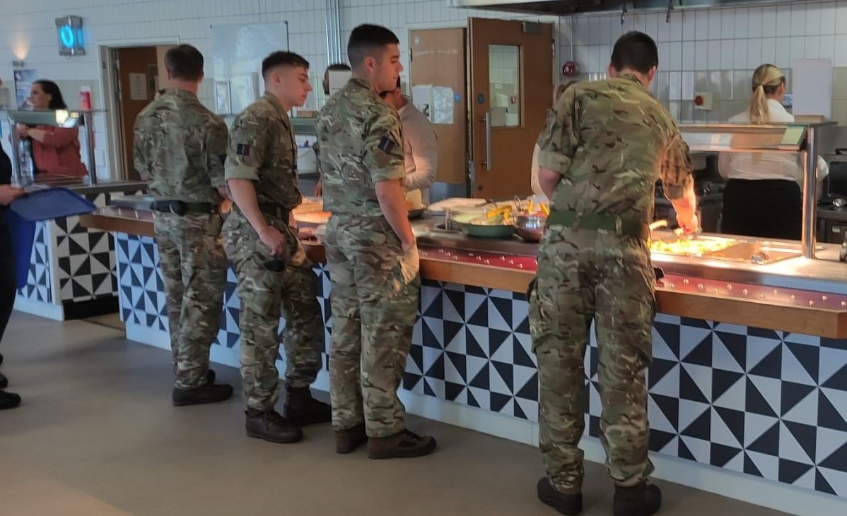 Image shows RAF aviators serving themselves food in a canteen.